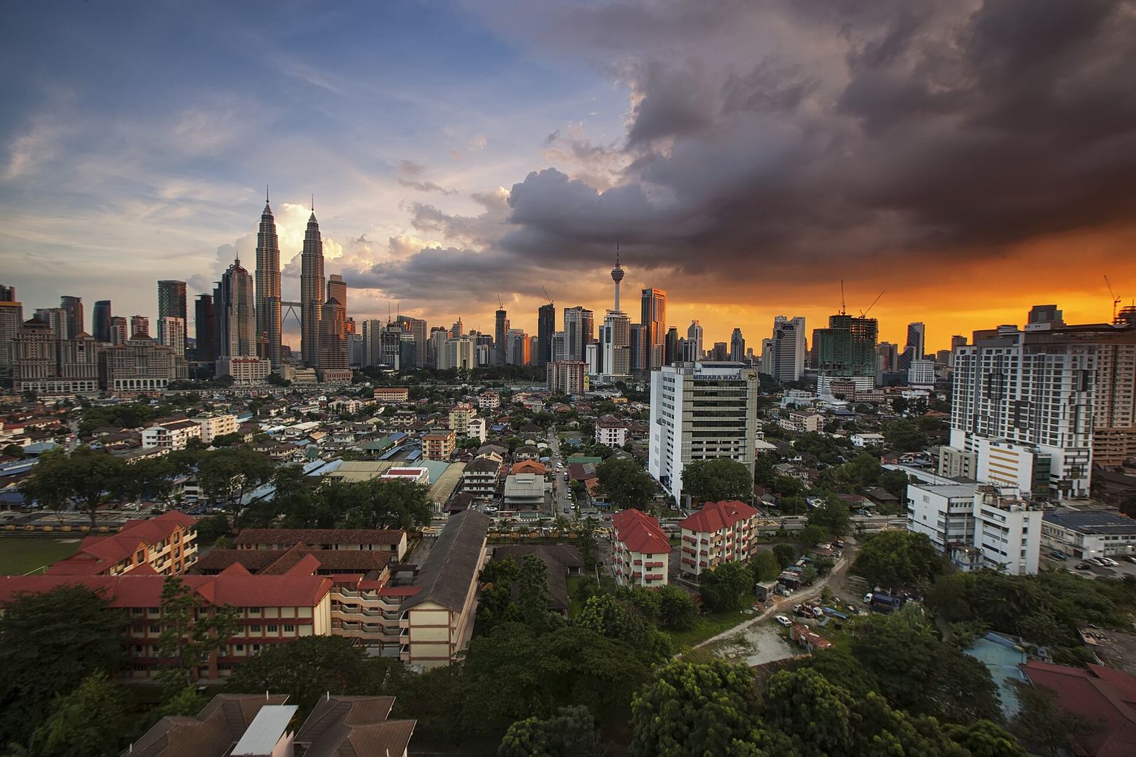 Kuala Lumpur skyline at dusk under heavy cloud